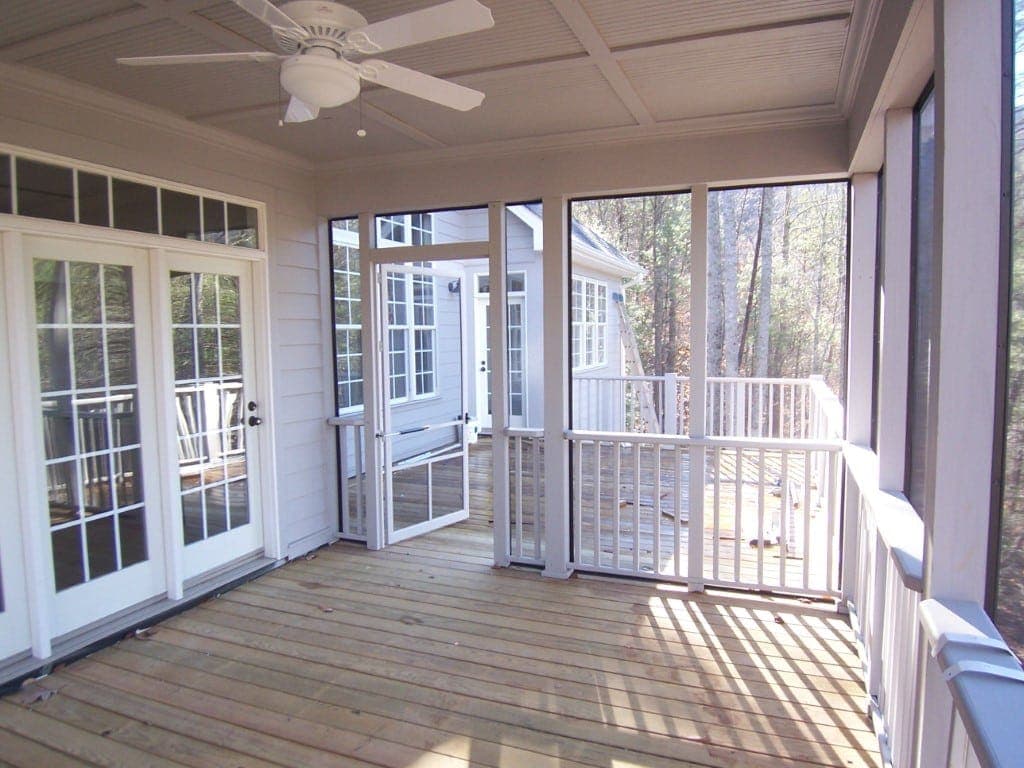 Screened porch with wooden deck and ceiling fan