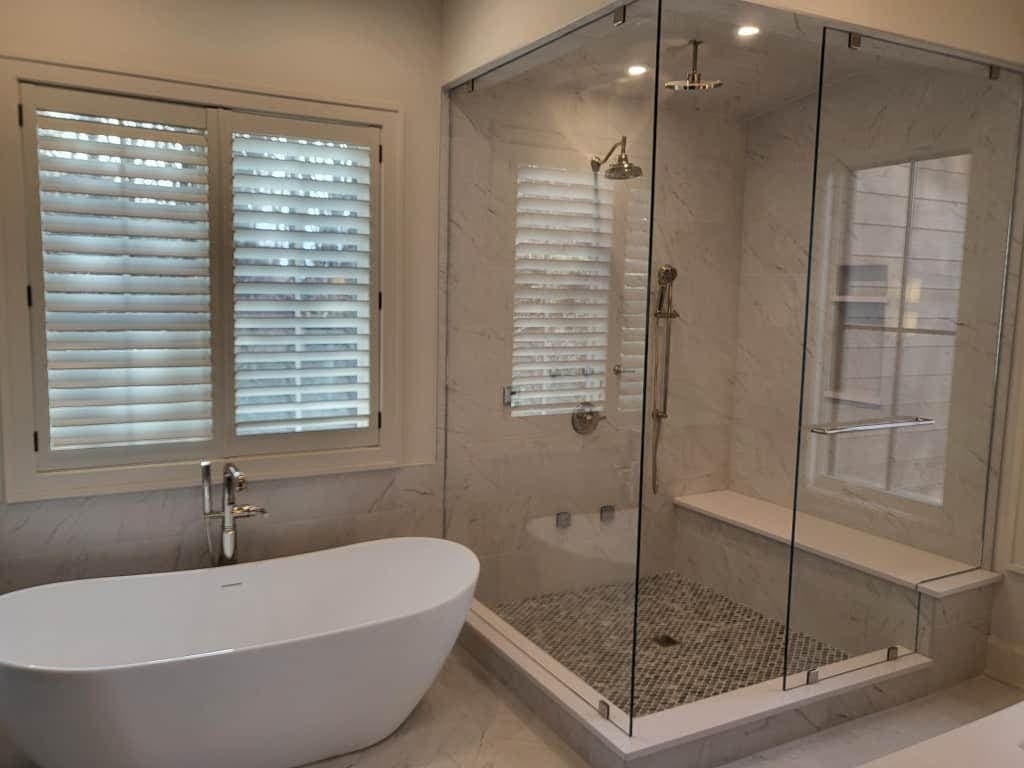 Elegant remodeled bathroom with soaking tub and glass shower